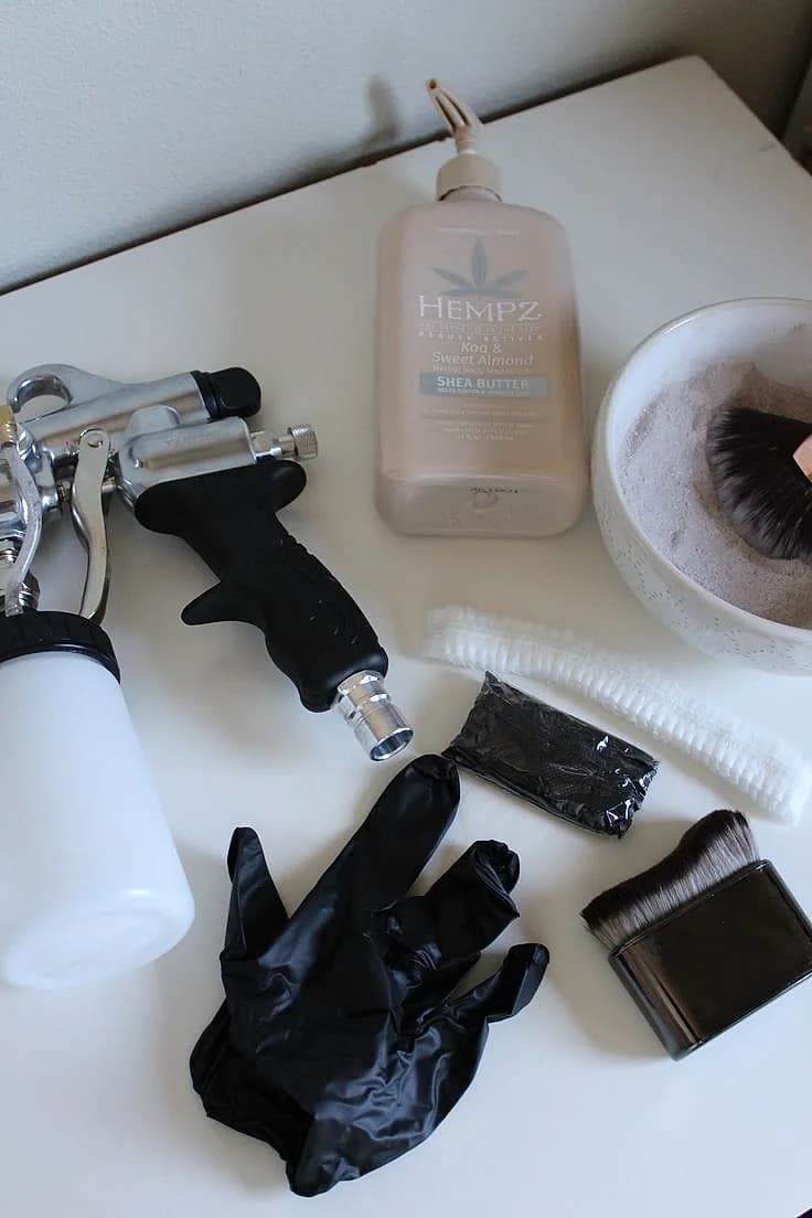 Glowtoure professional spray tan and aftercare products laid out — tanning solution, brushes, and barrier items